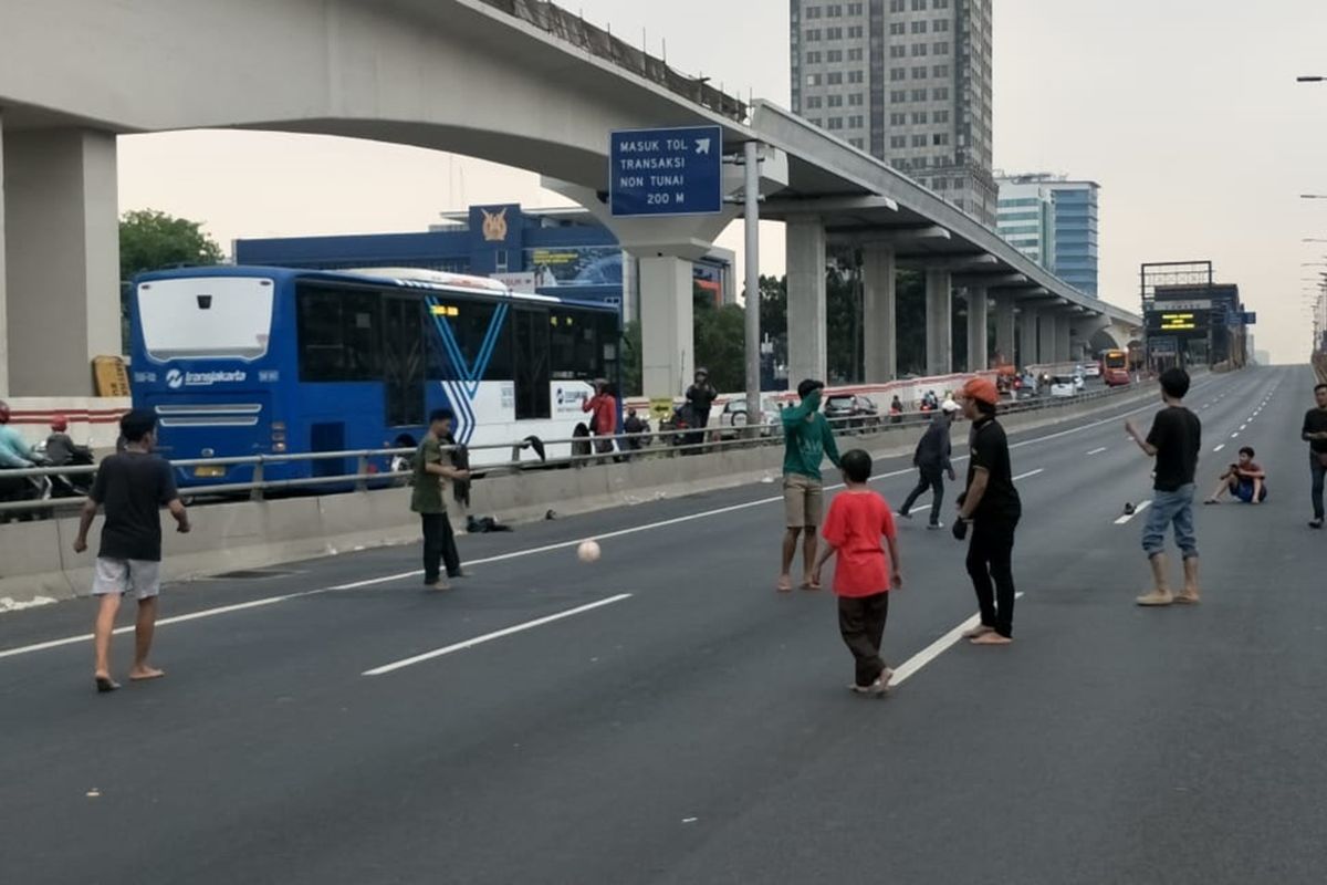 Sejumlah pemuda nampak bermain sepak bola di tengah Jalan Tol Dalam Kota Cawang arah Slipi yang ditutup, Rabu (25/9/2019).