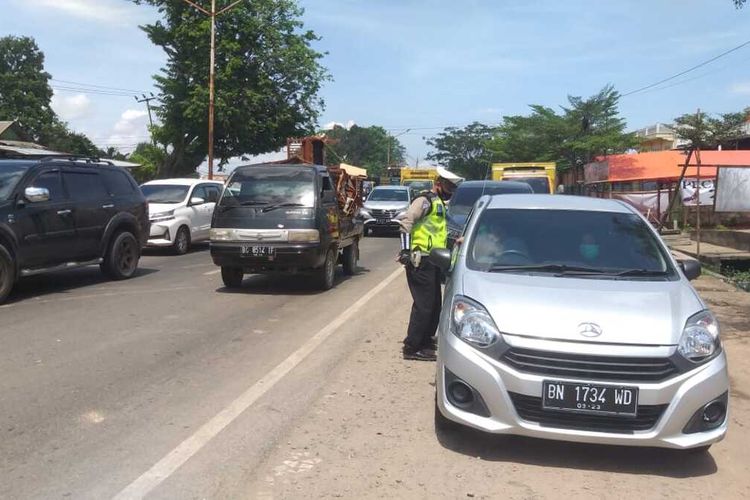 Pengendara mobil yang terkena operasi penyekatan di Simpang Nilakandi, Kertapati, Palembang, Sumatera Selatan, Kamis (6/5/2021). Pengendara ini akhirnya diperbolehkan lewat setelah mengaku dimintai uang Rp 100.00 oleh seorang oknum polisi yang melakukan pemeriksaan.