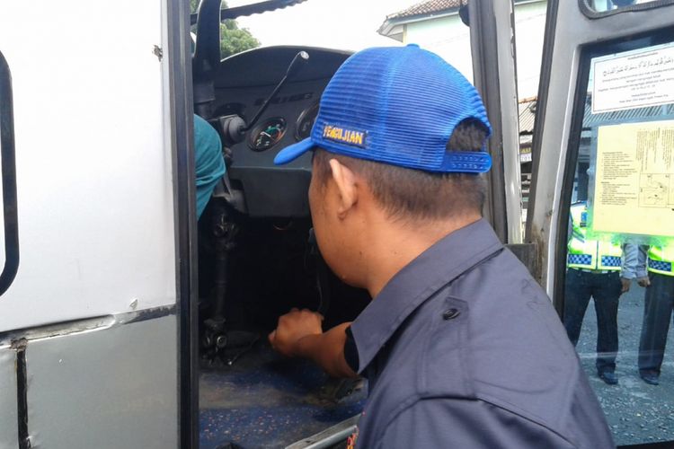Petugas Dinas Perhubungan menekan pedal rem bus AKDP untuk mengecek kelayakan bus di Pangandaran, Kamis (20/12/2018).