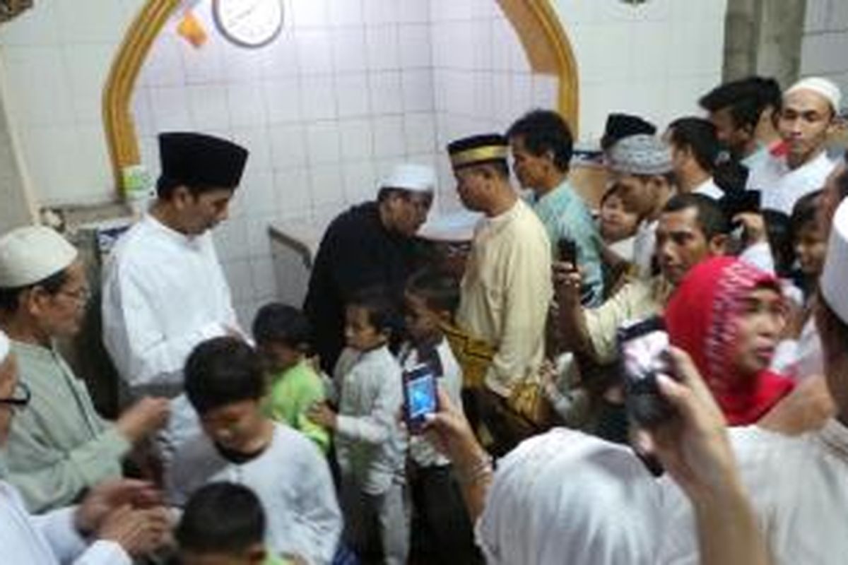 Gubernur DKI Jakarta Joko Widodo menyalami warga seusai menjalankan ibadah shalat tarawih di Masjid At Tawakkal di permukiman padat penduduk kawasan Menteng, Jakart Pusat, Selasa (9/7/2013) malam.