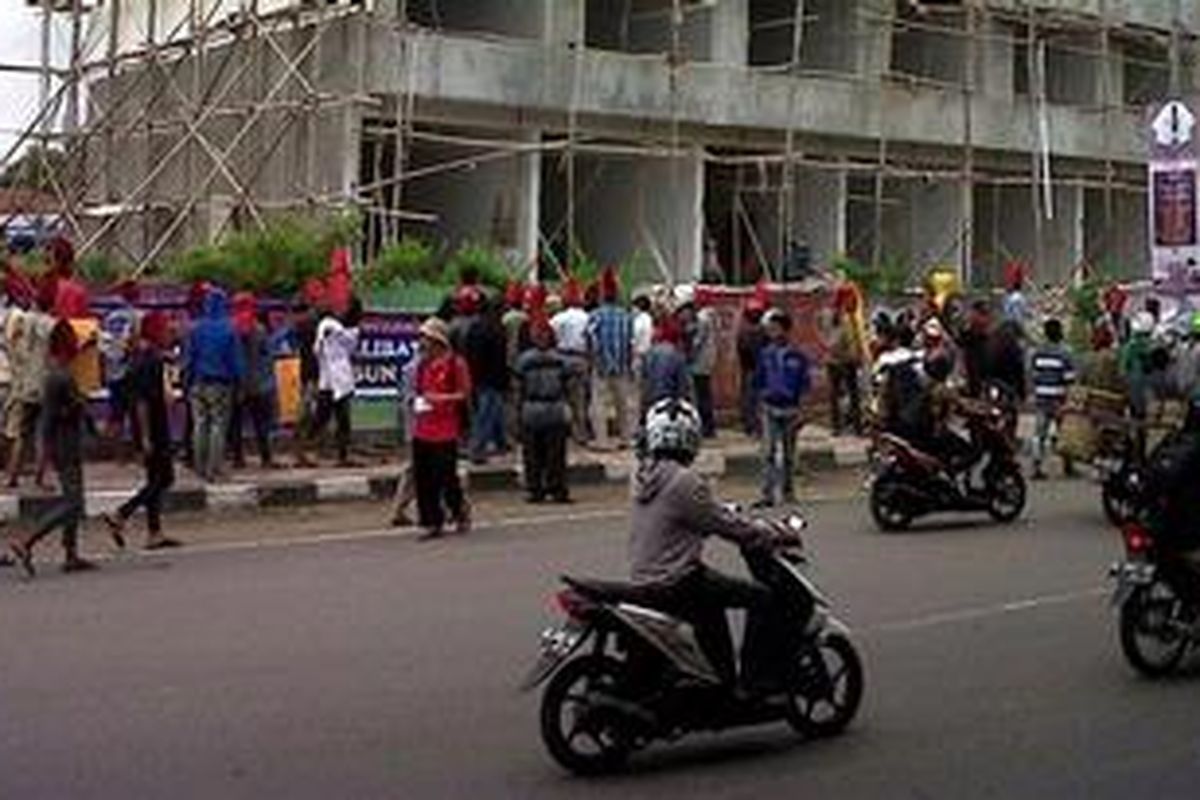 Ratusan warga berpakaian preman dengan bertopi merah layaknya pahlawan Nasional Sultan Hasanuddin mengusir buruh bangunan yang sedang bekerja di lokasi proyek pembangunan rumah toko di Jalan AP Pettarani, Makassar, Rabu (03/04/2013).