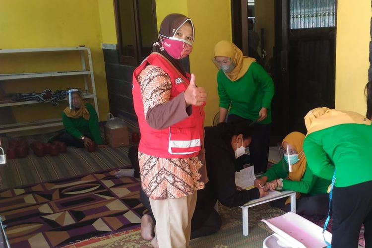 Dyah Retno A, kader kesehatan Puskesmas Sibela mengunjungi warga dalam kegiatan Posyandu door-to-door selama pandemi. Foto diambil belum lama ini.