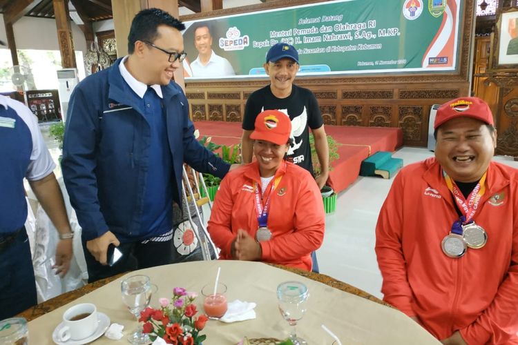 Menteri Pemuda dan Olahraga Republik Indonesia, Imam Nahrawi, menyapa dua atlet disabilitas asal Kabupaten Kebumen yang meraih medali perak Asian Para Games 2018, Sutikno (kanan) dan Famini, di dekat Alun-alun Kebumen, Jawa Tengah, Minggu (11/11/2018).