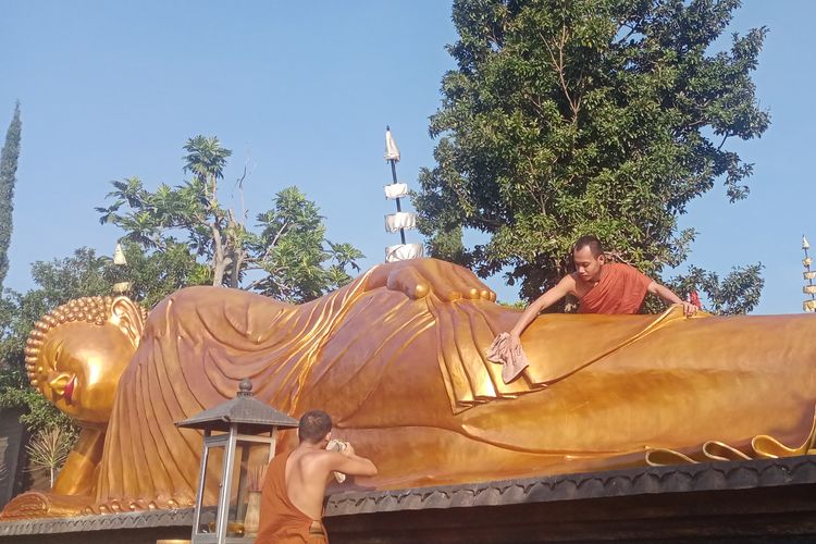 Patung Buddha tidur raksasa dibersihkan oleh para Samanera menggunakan lap dan air di Vihara Dhammadipa Arama, Kota Batu, Jawa Timur pada Rabu (31/5/2023). 