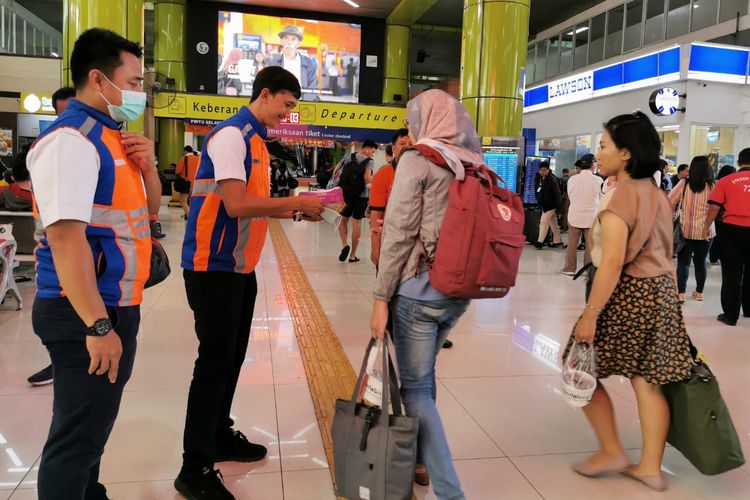 Pembagian masker pada penumpang KA oleh petugas PT KAI Daop 1 Jakarta di Stasiun Gambir, Jakarta Pusat, Rabu (29/1/2020).