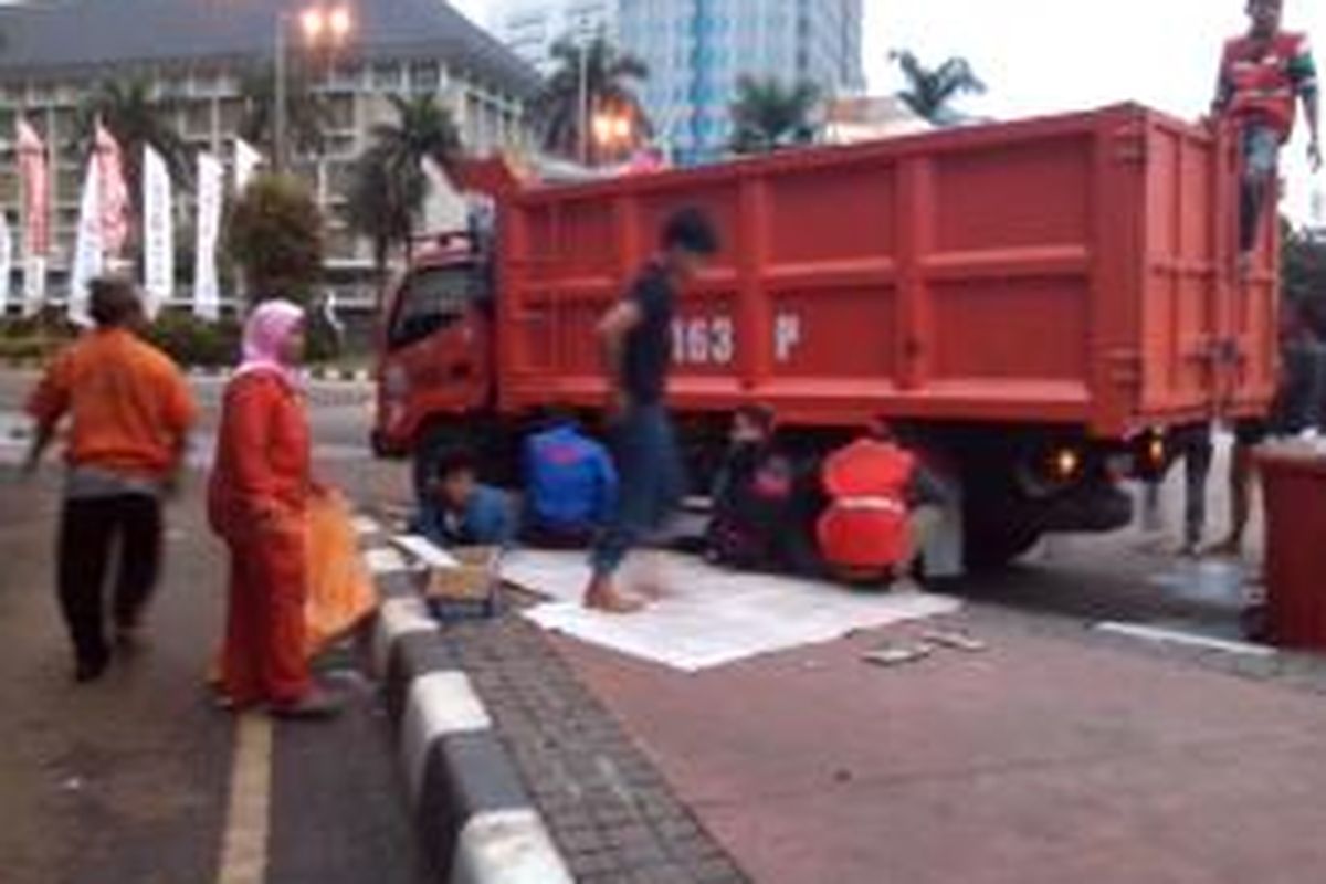 Sekumpulan remaja tidur di trotoar kawasan Monas usai ikuti Jakarta Night Festival dibangunkan oleh petugas kebersihan, Kamis (1/1/2014).