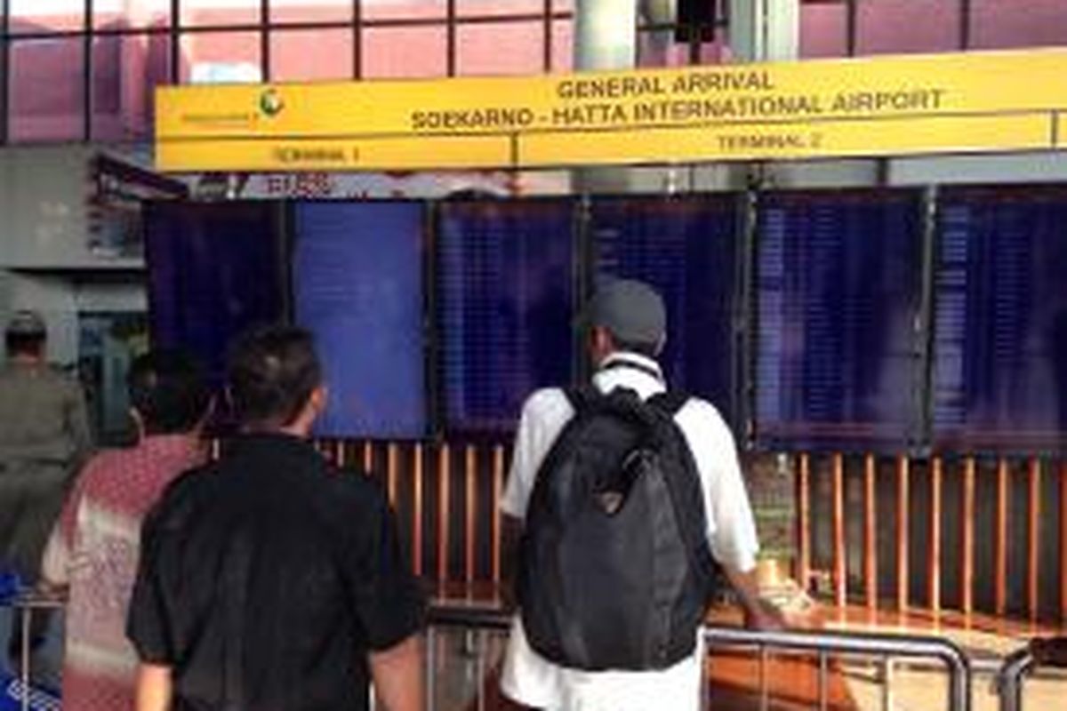 Sejumlah penumpang memperhatikan papan pengumuman elektronik yang ada di Terminal 1 Bandara Soekarno-Hatta, Kamis (18/6/2015). 