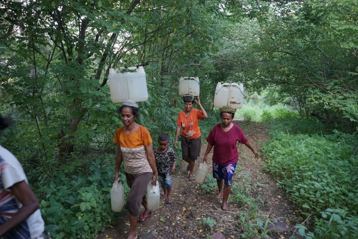 Warga Desa Banuan, NTT, harus berjalan jauh untuk mendapatkan air bersih.