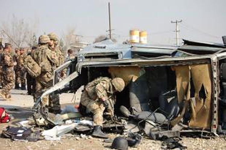 Sejumlah prajurit NATO memeriksa mobil milik kedubes Inggris di Afganistan yang hancur diserang bom bunuh diri di jalan poros Kabul-Jalalabad, Kamis (27/11/2014).