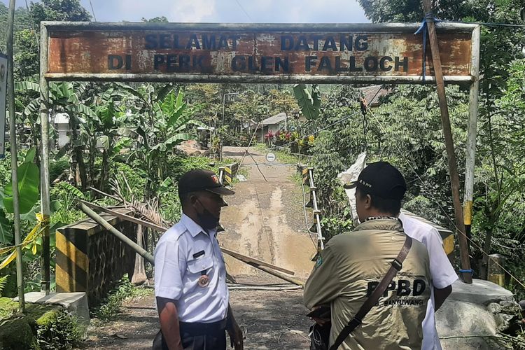 Plt Kepala Bidang Rehabilitasi dan Rekonstruksi BPBD Banyuwangi, Priyono, meninjau jembatan putus di Desa Karangharjo, Kecamatan Glenmore, Kabupaten Banyuwangi, Jawa Timur, Rabu (24/11/2021). 