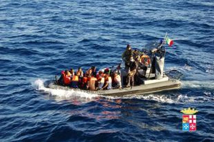 Dalam foto yang dirilis Angkatan Laut Italia ini terlihat sebuah perahu motor AL Italia membawa sejumlah imigran gelap yang diselamatkan di dekat Pulau Lampedusa, Italia pada Kamis (2/1/2014).