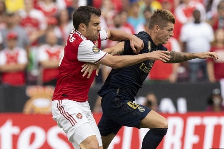 Gelandang Real Madrid, Toni Kroos (kanan), berusaha untuk melindungi bola dari pemain Arsenal Sokratis Papastathopoulos dalam pertandingan International Champions Cup antara Real Madrid vs Arsenal di FedExField di Landover, Maryland, pada 23 Juli 2019.