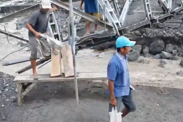 Warga melintas di jembatan gantung Kali Regoyo di Desa Sumberwuluh, Kecamatan Candipuro, Kabupaten Lumajang. (Kompas.com/Miftahul Huda)