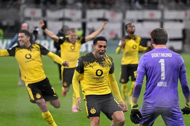 Para pemain Dormund merayakan kemenangan adu penalti setelah sepakan gelandang Frankfurt #08 Fares Chaibi (kiri) diselamatkan oleh Gregor Kobel (kanan) dalam laga Piala Jerman (DFB Pokal) putaran kedua antara Eintracht Frankfurt vs BVB Borussia Dormund di Frankfurt, Jerman barat pada 28 Oktober 2025. (Foto oleh Kirill KUDRYAVTSEV / AFP)