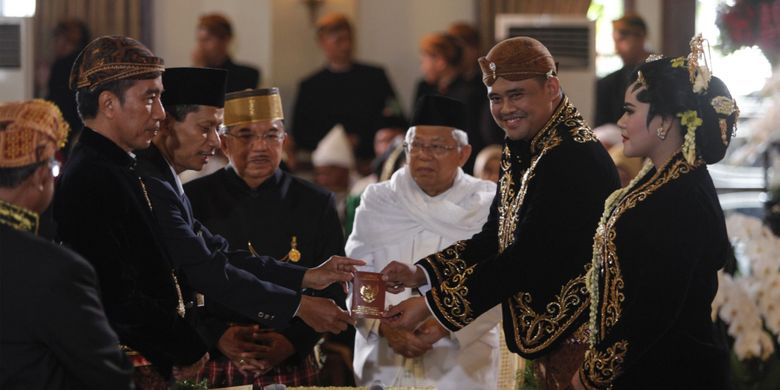 Menantu Presiden Joko Widodo, Bobby Nasution (kedua kanan) bersama istrinya, Kahiyang Ayu (kanan) menerima buku nikah dengan disaksikan Presiden Joko Widodo (kedua kiri), Wakil Presiden Jusuf Kalla (ketiga kiri) dan Ketua MUI KH Maruf Amin (keempat kanan) seusai ijab kabul di Gedung Graha Saba, Sumber, Solo, Jawa Tengah, Rabu (8/11/2017).