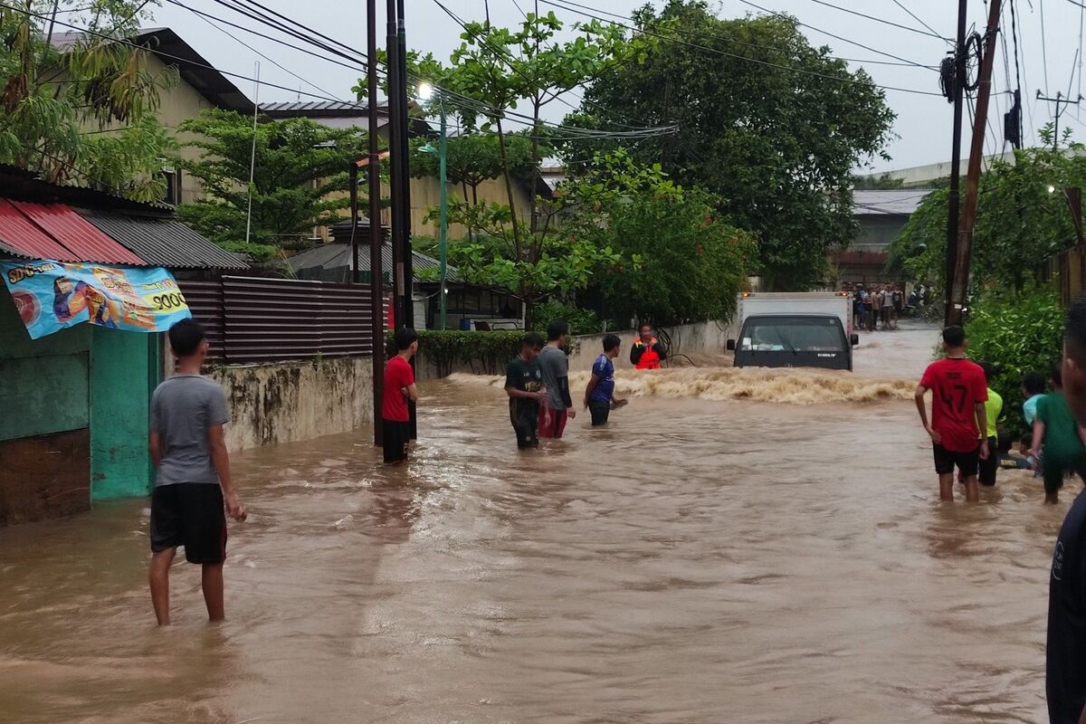 Sebuah mobil menerjang banjir yang terjadi di wilayah Cibuluh, Kota Bogor, Jawa Barat, Minggu (7/11/2021).