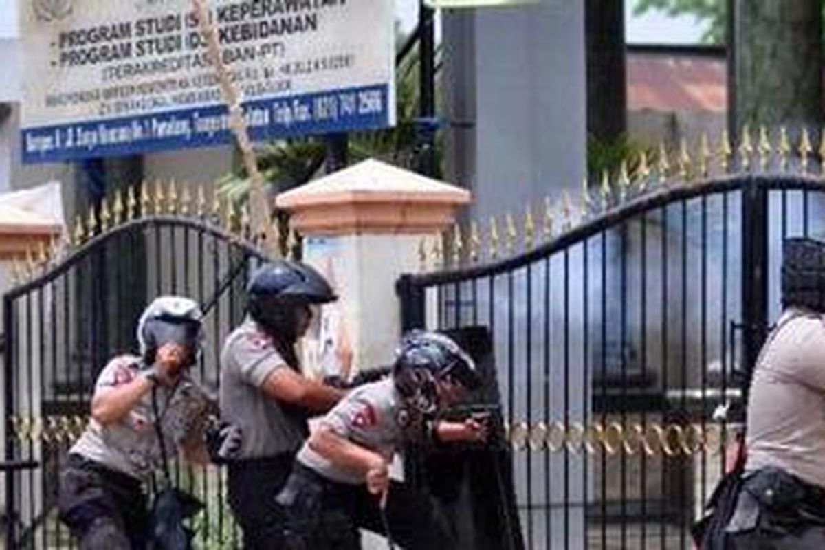 Polisi menembakan gas air mata untuk menghalau mahasiswa dalam bentrokan di Universitas Pamulang, Jalan Surya Kencana, Pamulang, Tangerang Selatan, Banten, (18/10/2012).  Bentrokan terjadi setelah para mahasiswa berdemonstrasi menolak kedatangan Wakapolri Komjen Nanan Sukarna. Lima polisi dan satu orang mahasiwa terluka dalam demontrasi. KOMPAS IMAGES/ANDREAN KRISTIANTO