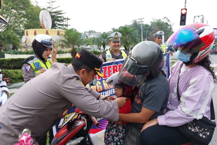 Kapolresta Pekanbaru Kombes Jefri Ronald Parulian Siagian memberikan helm gratis kepada seorang anak yang dibonceng orangtuanya tidak menggunakan helm di Jalan Yos Sudarso, Kota Pekanbaru, Riau, Selasa (12/9/2023).