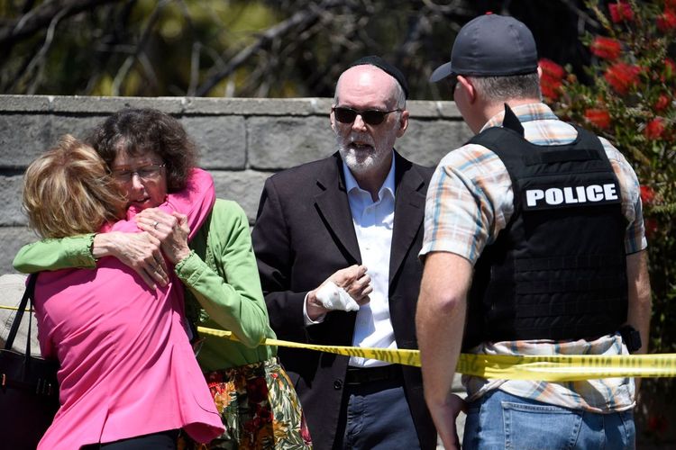 Dua orang perempuan berpelukan setelah penembakan yang terjadi di Sinagoge Chabad, Poway, Amerika Serikat, pada Sabtu siang (27/4/2019). 1 orang tewas dalam penembakan yang dilakukan remaja berusia 19 tahun tersebut.