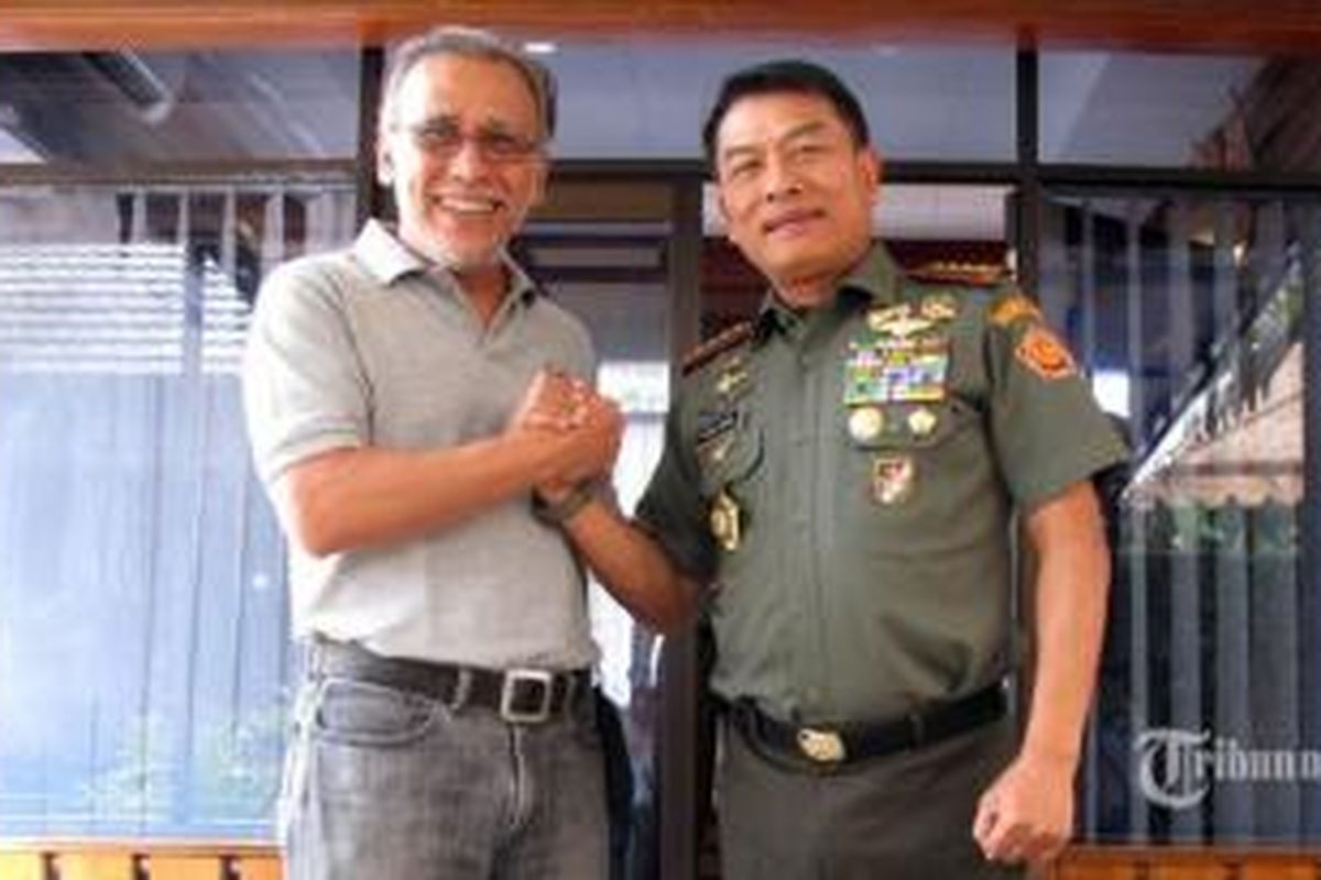 Panglima TNI, Jenderal Moeldoko (kanan), melakukan salam komando dengan artis musik Virgiawan Listanto atau Iwan Fals ketika ia berkunjung ke rumah Iwan di Leuwinanggung, Depok, Jawa Barat, Sabtu (9/8/2014). Moeldoko hadir untuk menjadi pembicara dalam diskusi Obrolan Penting Sabtu Ini (Opsi) bersama puluhan penggemar Iwan, yang bergabung dalam Orang Indonesia (OI).
