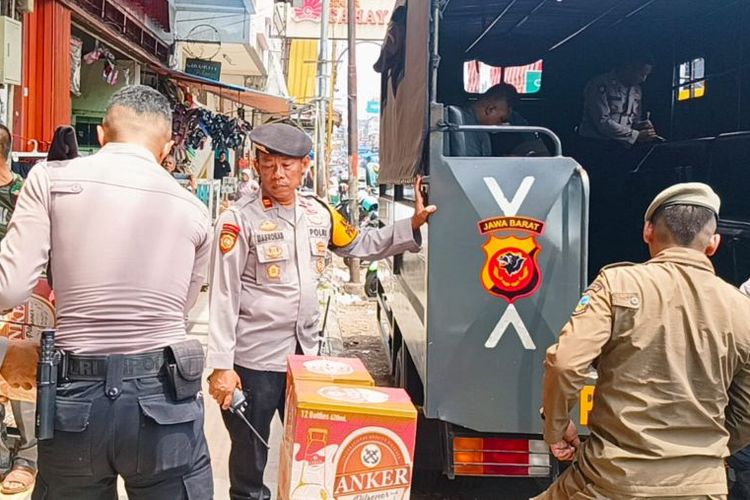 Polisi mengangkut minuman keras yang diamankan dari truk dan toko di Jalan Ahmad Yani, Garut Kota, Kabupaten Garut, Jawa Barat, Rabu (22/11/2023).