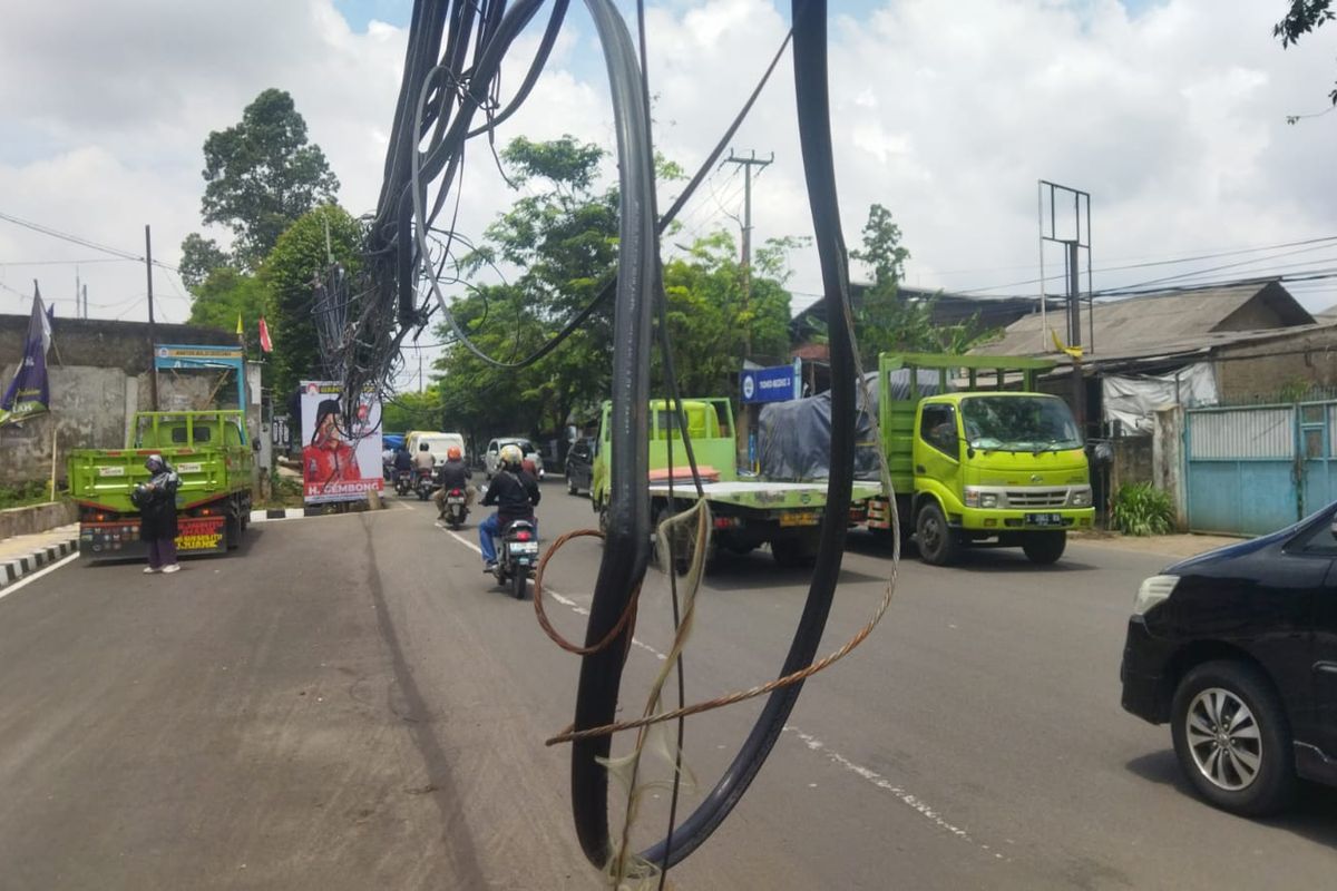 Warga di sekitar Jalan Hasyim Ashari, Kecamatan Pinang, Kota Tangerang mengeluhkan kabel semrawut yang menjuntai di tengah jalan raya di titik lokasi tersebut. Berdasarkan pantauan Kompas.com pada Senin (13/3/2023) pagi menjelang siang, kabel tersebut tampai menjuntai dengan jarak ketinggian dari tanah hanya sekitar 100-150 sentimeter saja.