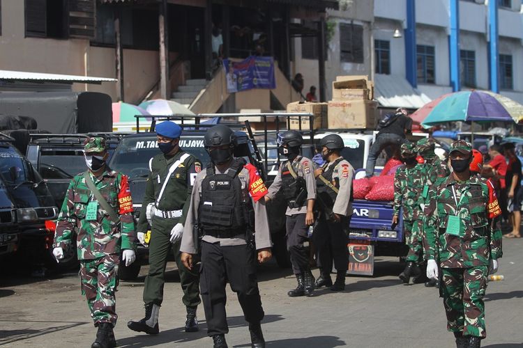 Petugas dari TNI dan POLRI melakukan patroli serta menghimbau warga untuk mengikuti protokol kesehatan di Pasar Lima, Banjarmasin, Kalimantan Selatan, Sabtu (6/6/2020). Patroli tersebut untuk memberikan imbauan serta edukasi tentang protokol kesehatan COVID-19 yang menjadi prosuder tatanan normal baru (New Normal) di tempat keramaian. ANTARA FOTO/Bayu Pratama S/hp.