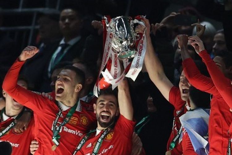 Gelandang Manchester United asal Portugal, Bruno Fernandes (tengah), mengangkat trofi Piala Liga Inggris. Man United tampil sebagai juara Piala Liga Inggris atau Carabao Cup 2022-2023 usai mengalahkan Newcastle United 2-0 di Stadion Wembley, London, pada Minggu (26/2/2023) malam WIB.