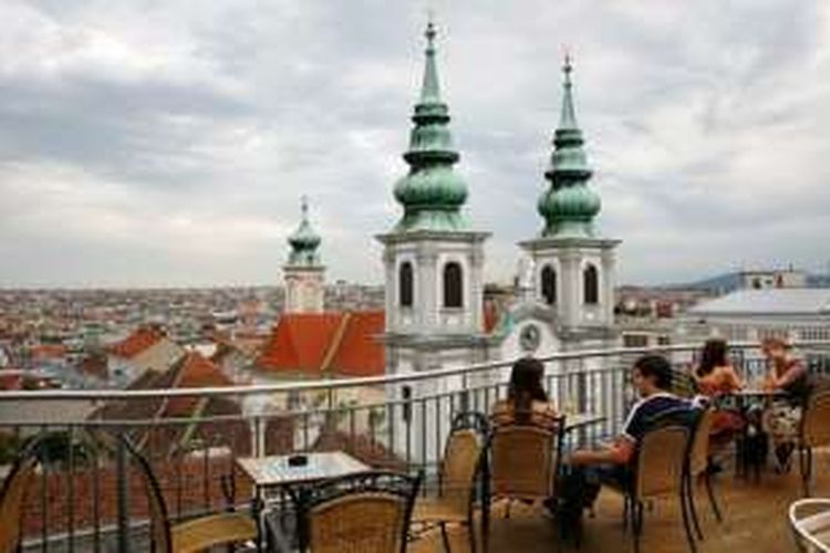 Sejumlah warga kota Vienna, Austria sedang menikmati suasana kota dari sebuah kafe di atas sebuah gedung.