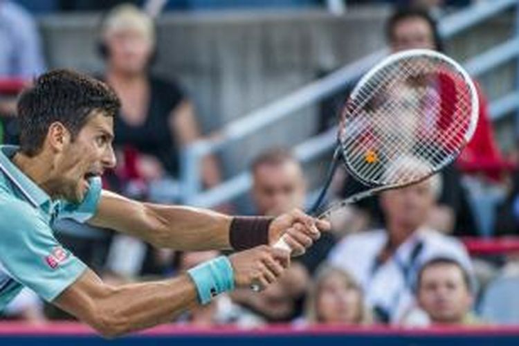 Petenis Serbia, Novak Djokovic, mengembalikan bola Richard Gasquet dari Perancis, saat bertemu pada babak perempat final Rogers Cup, di Uniprix Stadium Montreal, Kanada, Jumat (9/8/2013).