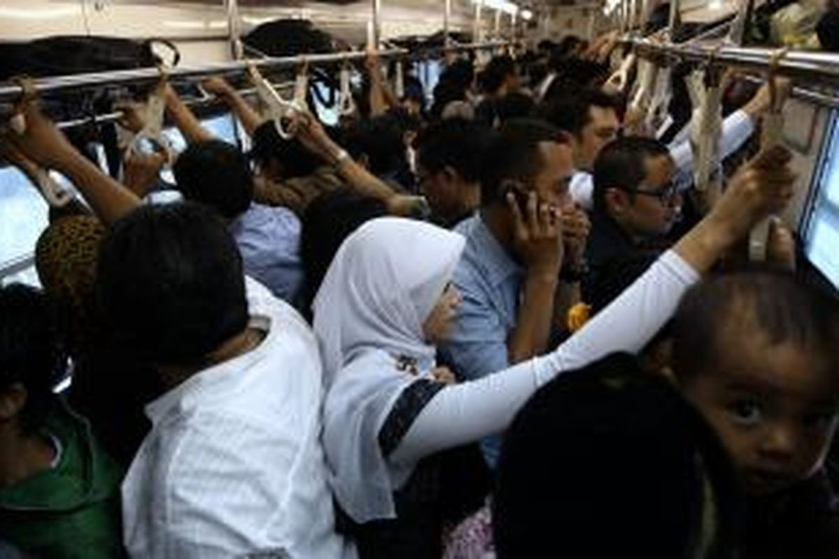 Pengguna Kereta Commuter Line berdesakan di dalam gerbong saat jam sibuk menuju Stasiun Pasar Tanah Abang, Jakarta Pusat, Selasa (2/4/2013). Penambahan jumlah perjalanan KRL dari 514 menjadi 575 perjalanan disambut baik oleh pengguna setia KRL. 
