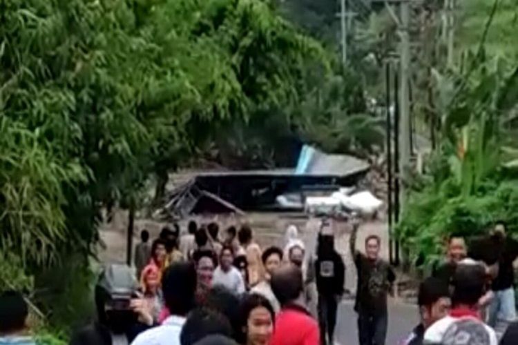 Warga berlarian saat melihat bangunan hanyut terbawa banjir bandang di Minahasa Tenggara, Sulawesi Utara.