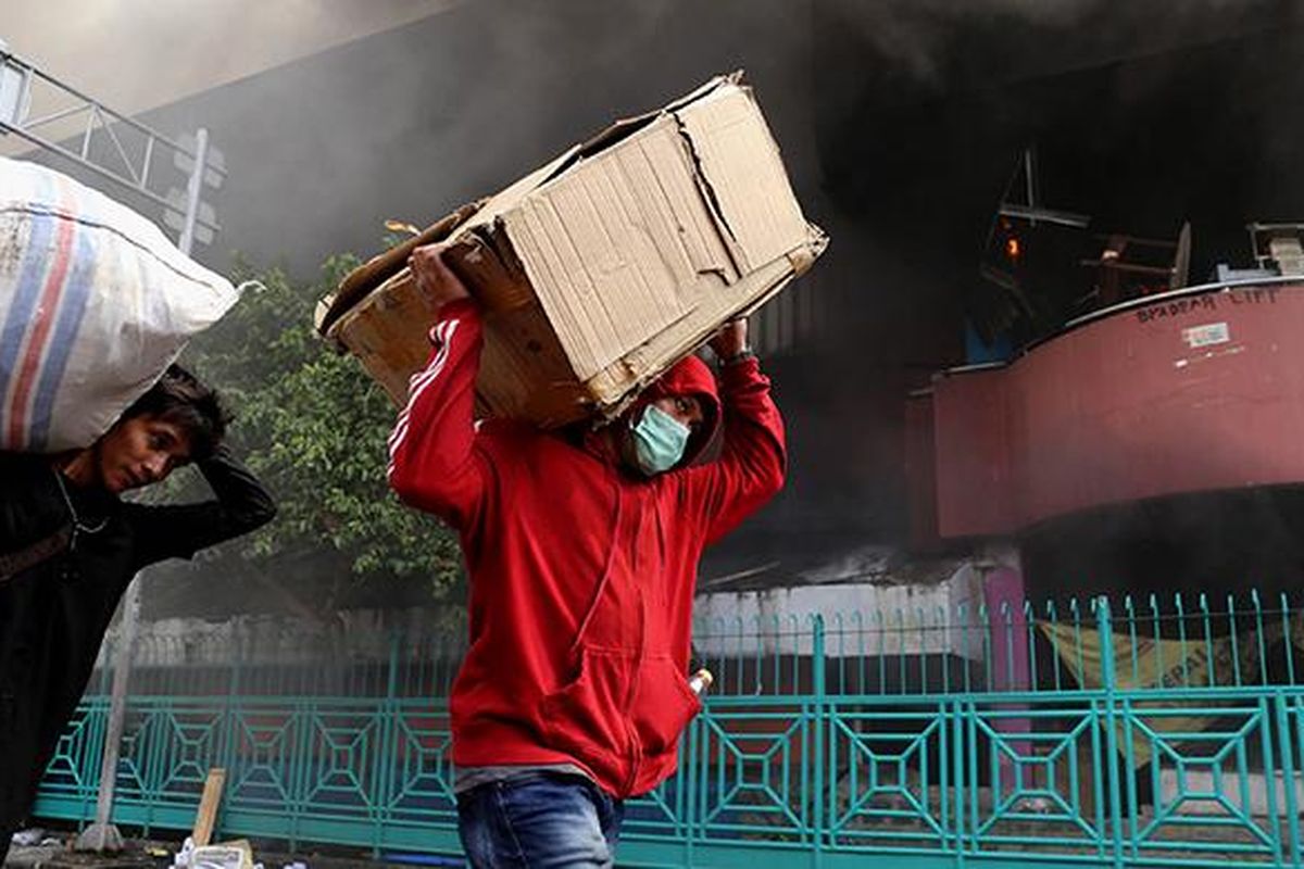 Pedagang menyelamatkan barang-barangnya dari lokasi Pasar Senen yang terbakar di Jakarta Pusat, Kamis (19/1/2017). Kebakaran yang terjadi sejak pukul 04.30 WIB itu diduga karena korsleting listrik di lantai satu Blok III dan dalam penanganan petugas yang mengerahkan sedikitnya 50 unit mobil pemadam kebakaran.