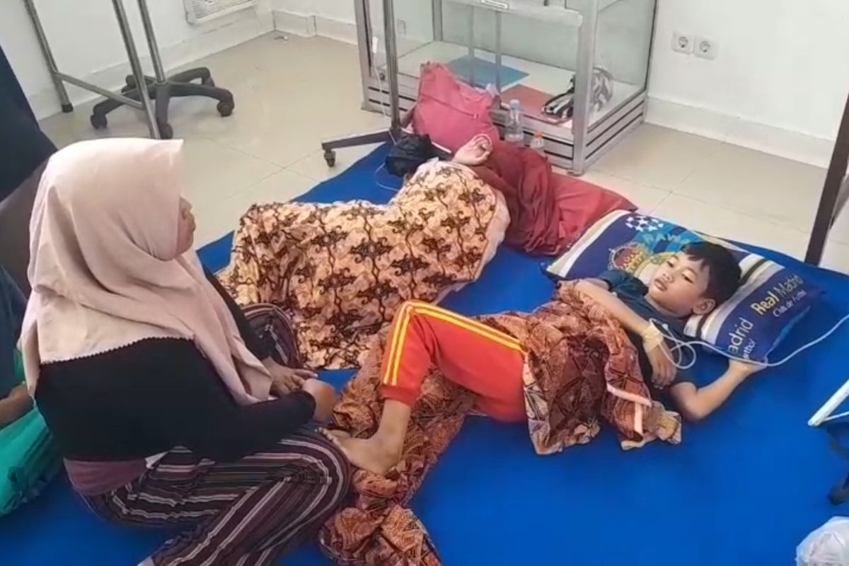 Seorang ibu rumah tangga menunggui anaknya yang diduga keracunan makanan dari MBG di Puskesmas Mantingan, Kecamatan Mantingan, Kabupaten Ngawi, Jawa Timur, Kamis (4/12/2025).