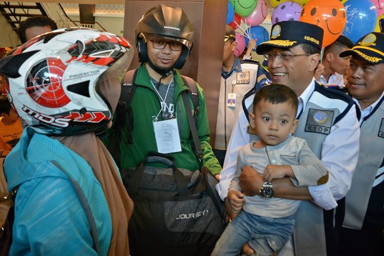 Menteri Perhubungan Budi Karya Sumadi (kedua kanan) menggendong seorang anak sambil berbicang dengan pemudik gratis bersepeda motor asal Jakarta yang baru turun dari KM Sabuk Nusantara 80, di Pelabuhan Tanjung Emas, Semarang, Jawa Tengah, Rabu (13/6). Menurut Menhub tingkat keterisian kuota mudik gratis menggunakan kapal laut pada Lebaran 2018 mencapai 90 persen dari 30 ribu kuota pemudik yang disiapkan. 