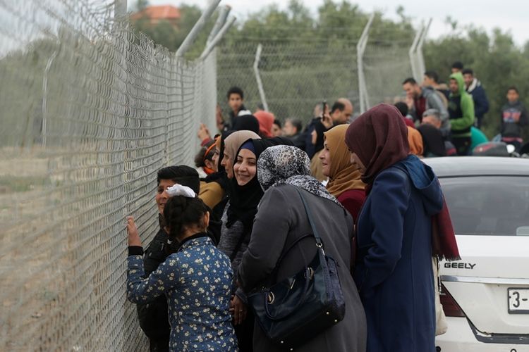 Sekelompok perempuan menonton pertandingan sepak bola dari balik pagar di stadion kamp pengungsi Nuseirat, Jalur Gaza, Minggu (28/1/2018).