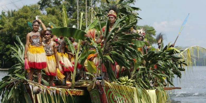 Para peserta tari Isolo atau Isosolo, saat menuju panggung menggunakan perahu pada acara Festival Danau Sentani 2016 di Kabupaten Jayapura, Papua, Senin (20/6/2016). Tari Isolo selalu dibawakan dalam FDS 2016 yang mengisahkan hubungan kerukunan antar suku dengan membawa hasil bumi.