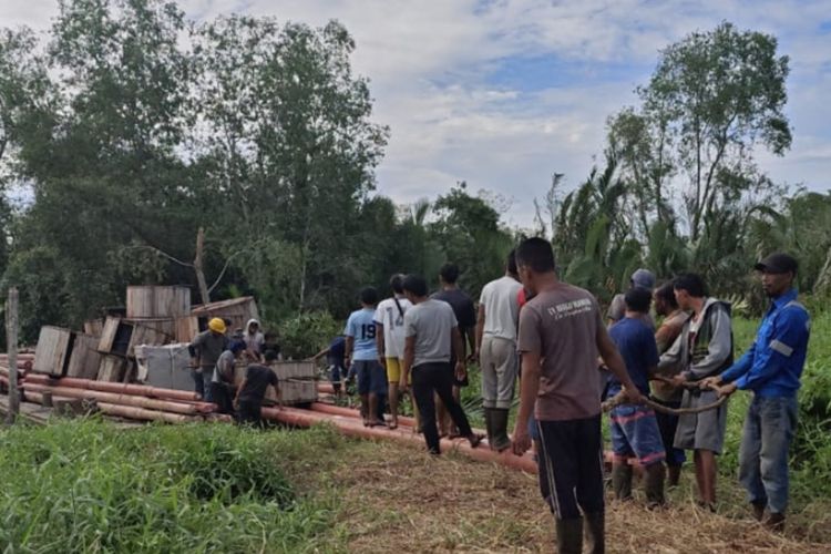 Petugas PLN bersama warga berjibaku membawa material untuk membangun jaringan listrik di daerah pelosok di Kelurahan Pelangiran, Kecamatan Pelangiran, Kabupaten Indragiri Hilir, Riau, pada 26 September 2024.