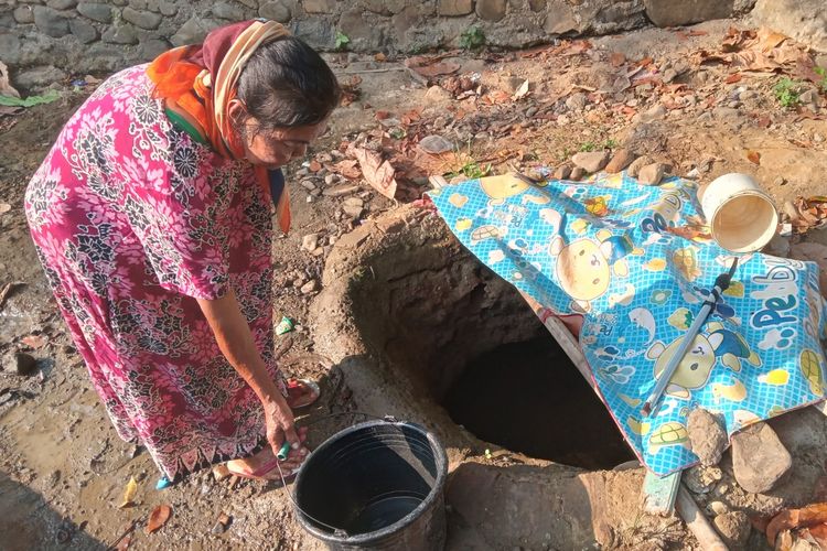 Seorang warga di Kecamatan Cibeber, Kabupaten Cianjur, Jawa Barat, Senin (9/10/2023) tengah mengambil air dari lobang pinggir sungai yang sengaja dibuat menyusul kemarau panjang tahun ini yang menyebabkan bencana kekeringan dan krisis air bersih.