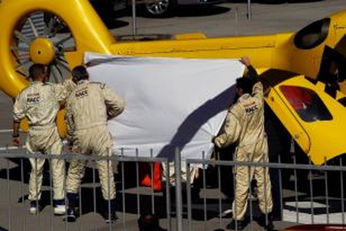 Pebalap McLaren Honda asal Spanyol, Fernando Alonso, dilindungi oleh kru dan tim medis setelah mengalami kecelakaan saat menjalani uji coba pramusim di Sirkuit de Catalunya, Barcelona, Minggu (22/2/2015).