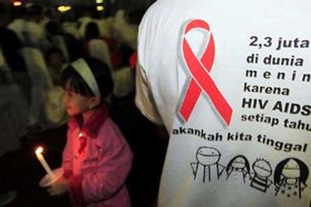 Aktivis menyalakan puluhan lilin yang membentuk pita saat malam renungan AIDS Nusantara di Halaman Monumen Nasional (Monas), Jakarta Pusat, Sabtu (12/6/2010) malam. Malam renungan bertujuan menyosialisasikan pencegahan AIDS serta menggugah masyarakat agar dapat hidup berdampingan dengan Orang Dengan HIV/AIDS (ODHA) dalam kehidupan sehari-hari. 
