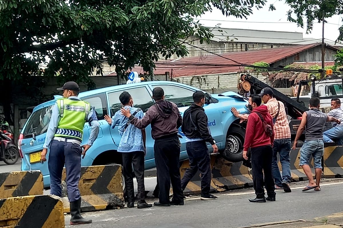 Sebuah mobil taksi menabrak separator jalur bus di Jalan Daan Mogot, Kebon Jeruk, Jakarta Barat, tepat sebelum fly over Pesing, pada Rabu (26/10/2022) pukul 10.00 WIB. 