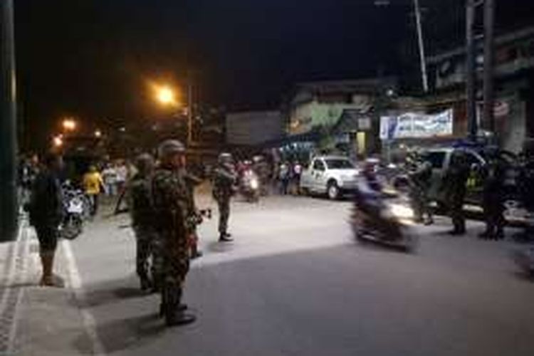 Aparat TNI POlri bersiaga dengan senjata laras panjang saat ratusan warga Desa Batu Merah Kecamatan Sirimau Ambon memblokade jalan Jenderal Sudriman, Jumat (15/1/2017) malam. 
