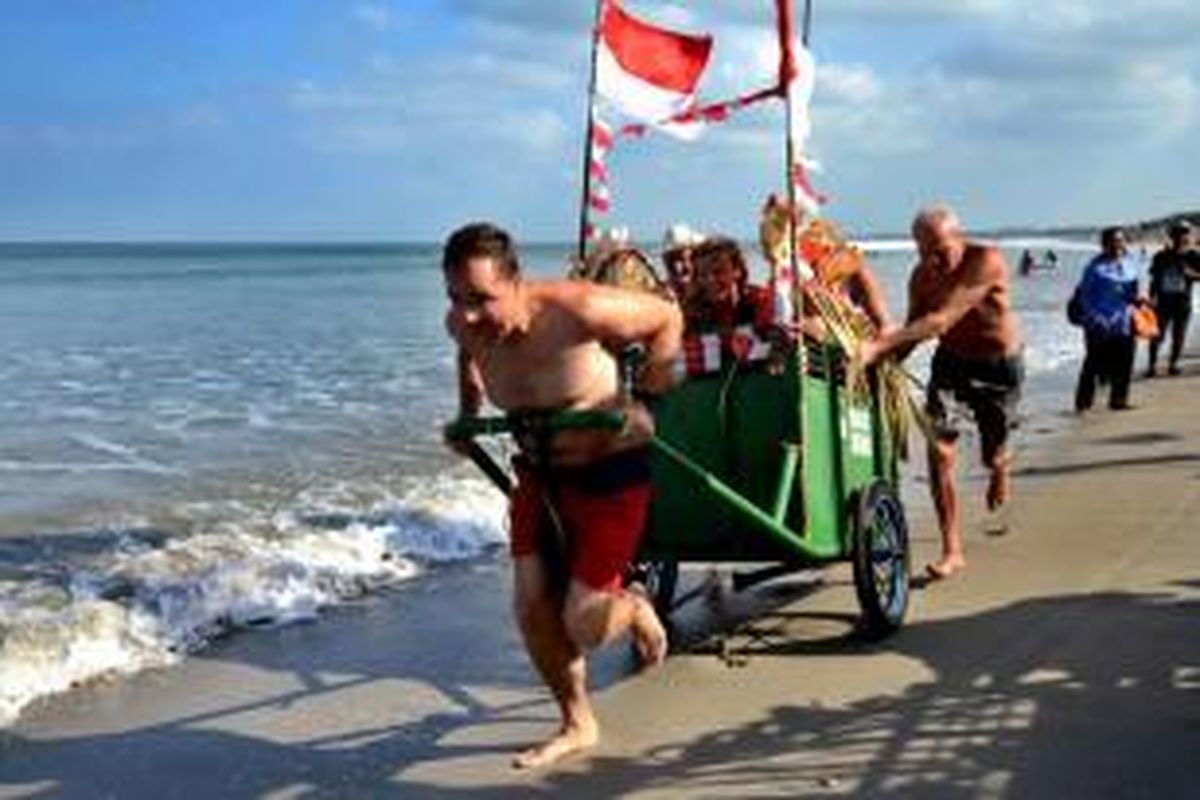 Turis asing berpartisipasi dalam lomba gerobak sampah untuk memperingati HUT ke-70 Indonesia di Pantai Kuta, Denpasar, Senin, 17 Agustus 2015.  