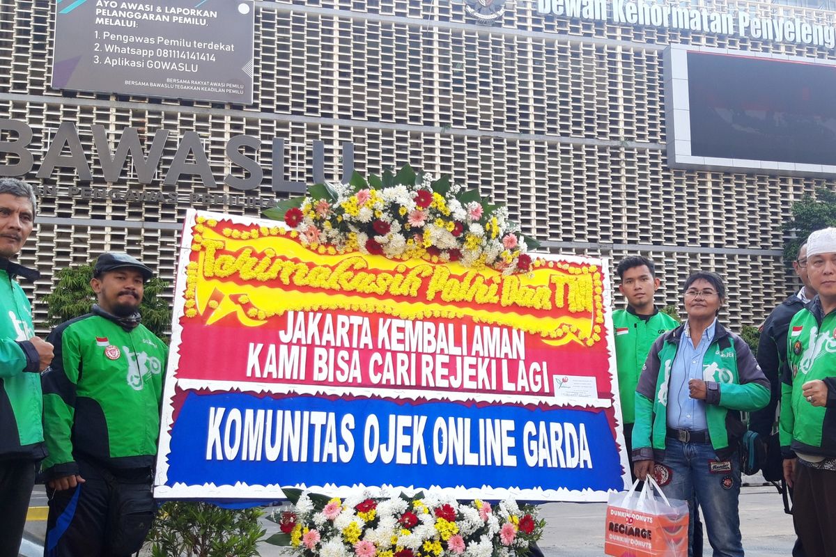 GARDA Ojek Online berikan papan karangan bunga kepada aparat TNI Polri di depan Bawaslu sebagai ucapan terima kasih, Senin (27/5/2019)