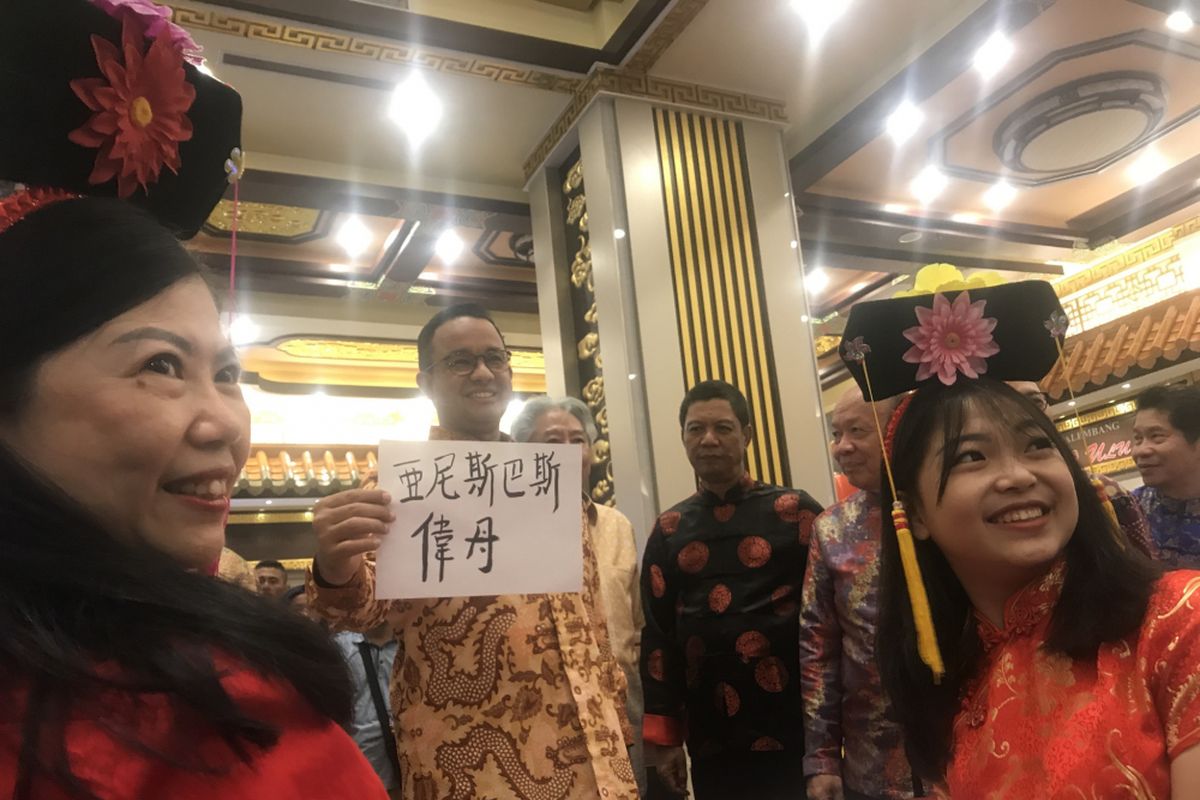 Gubernur DKI Jakarta, Anies Baswedan, berfoto dengan membawa cinderamata bertuliskan huruf Tionghoa, Selasa ( 19/2/2019) di China Town Point, Glodok, Jakarta Barat, dalam Festival Pecinan 2019. 
