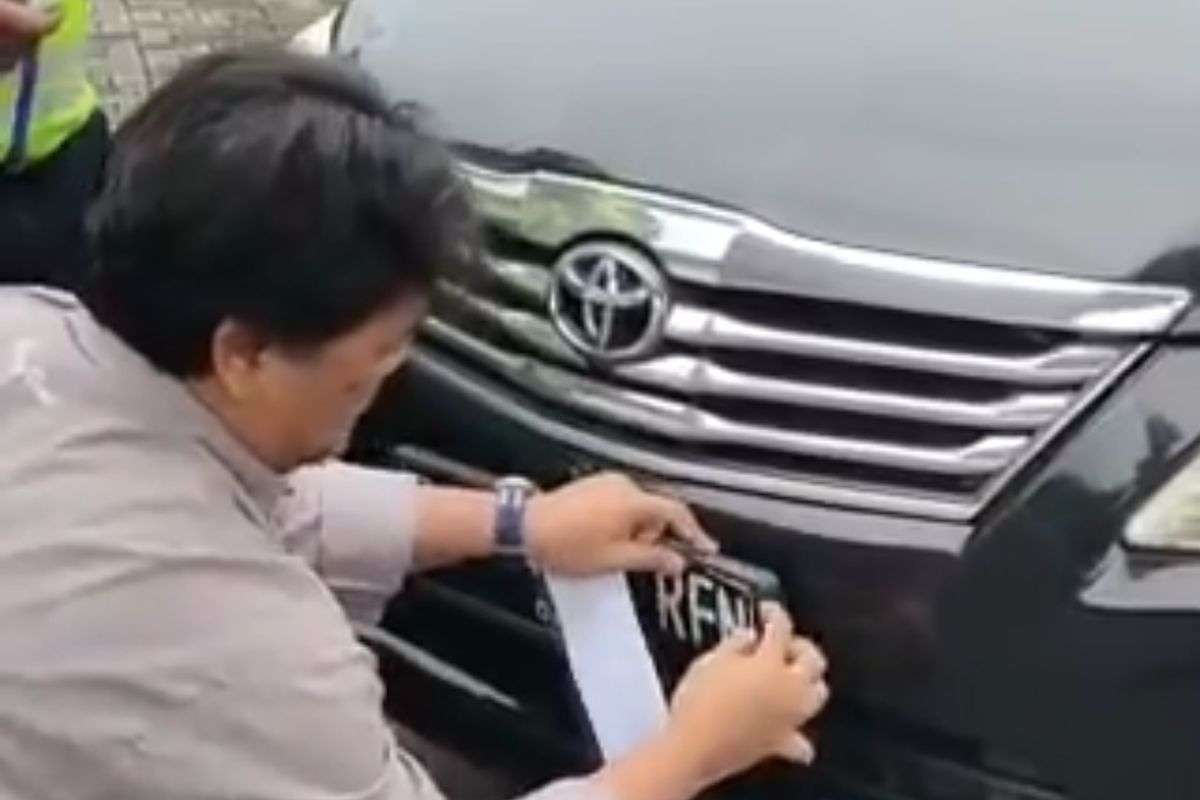 Pengendara mobil yang ditegur polisi karena menggunakan pelat nomor bodong di Cawang, Jakarta Timur, Senin (26/12/2022).