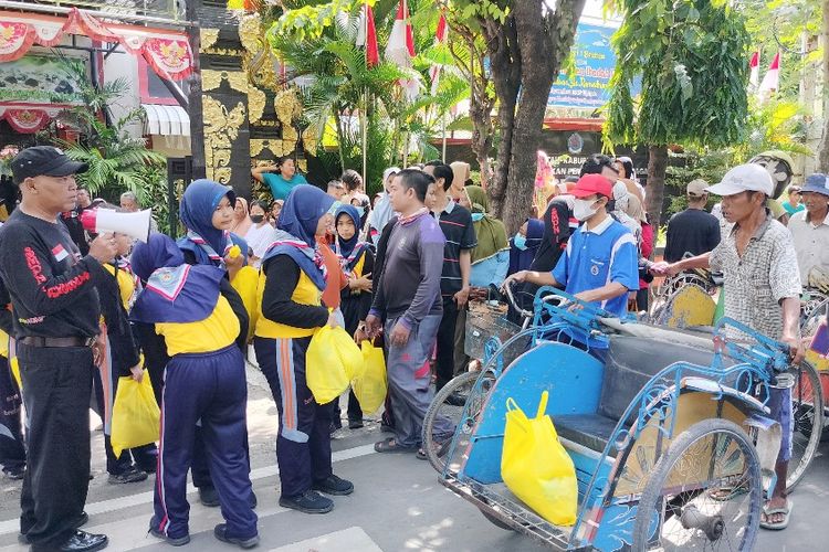 Puluhan siswa- siswi di salah satu SMP di Kabupaten Brebes, Jawa Tengah turun ke jalan untuk berbagi bingkisan sembako untuk ratusan tukang becak, pengemudi ojek online, dan penyapu jalan, Sabtu (6/4/2024). 