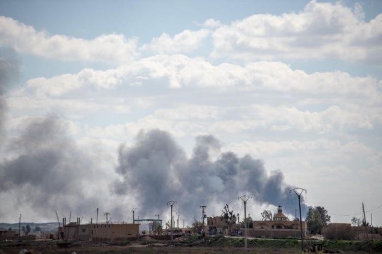 Asap mengepul di wilayah kantong terakhir ISIS di Baghouz, Deir Ezzor, Suriah, pada Sabtu (2/3/2019).  (AFP/BULENT KILIC)