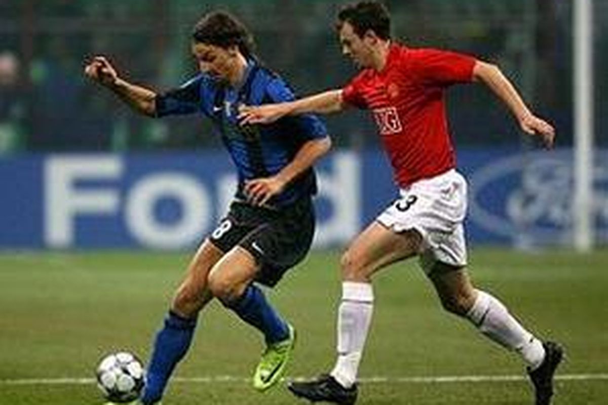 Striker Inter Milan, Zlatan Ibrahimovic (kiri), bertarung dengan bek Manchester United, Jonny Evans, dalam duel babak 16 besar Liga Champions di Stadion Giuseppe Meazza, Selasa (24/2).